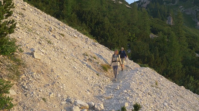 图片:一对情侣在爬山时欣赏风景视频素材