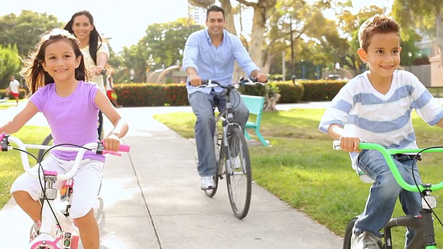 全家骑自行车穿过夏日公园视频下载