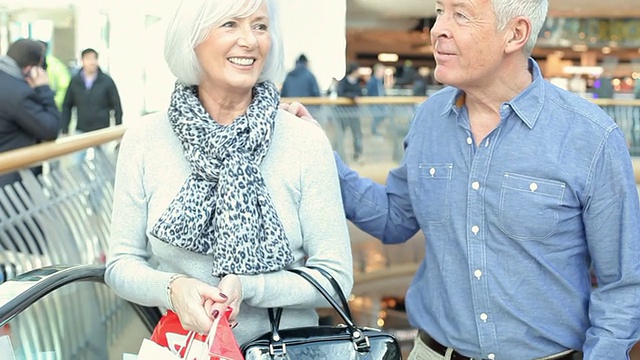 购物中心电梯上快乐的老年夫妇视频素材
