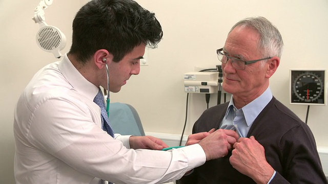 医生听老年男性病人的胸部视频素材