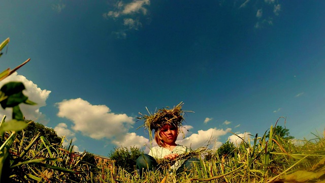 一个农夫的金发女儿用稻草编了一个花环，背景是蓝天和浮云视频下载