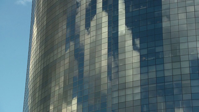 高耸的镜面摩天大楼反射着流逝的云视频素材