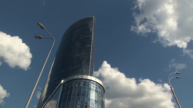 在飞翔的云的背景上有镜像的摩天大楼。延时。视频素材