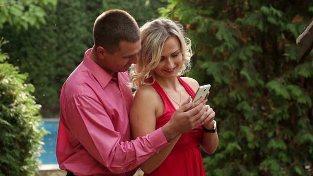 情侣在公园里玩手机视频素材