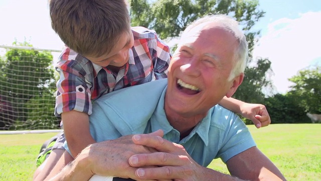 爷爷和孙子踢足球的慢动作镜头视频素材