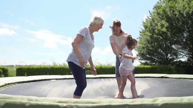 祖母，孙女和妈妈在蹦床上蹦跳视频素材