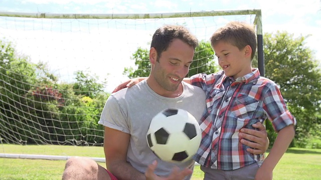 爸爸和儿子在家里的花园里踢足球视频下载