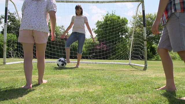 一家人一起在花园里踢足球视频素材