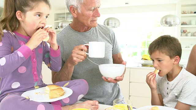 爷爷奶奶和孙子在厨房吃早餐视频素材