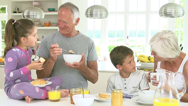 爷爷奶奶和孙子在厨房吃早餐视频素材