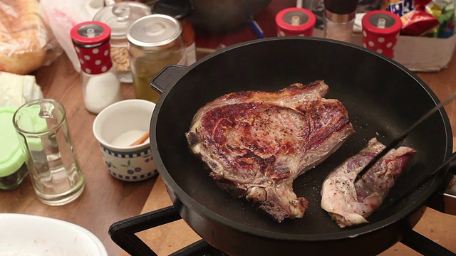 家庭烹饪-在煎锅里烤丁字骨牛排视频素材