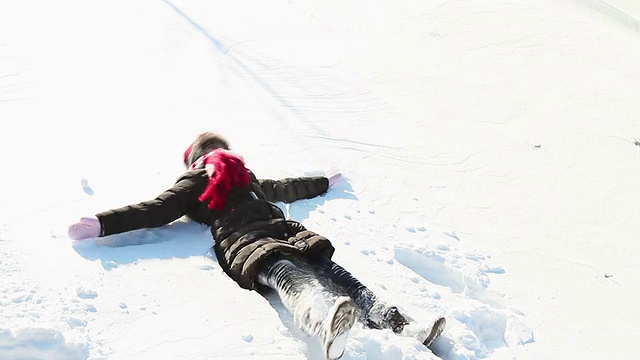 小女孩在雪地里做天使视频素材