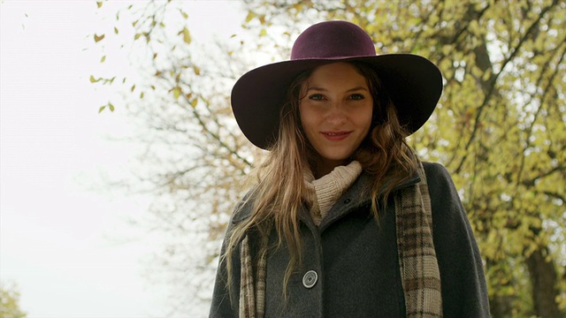 一位戴着帽子的可爱年轻女子低头看着镜头微笑着视频素材