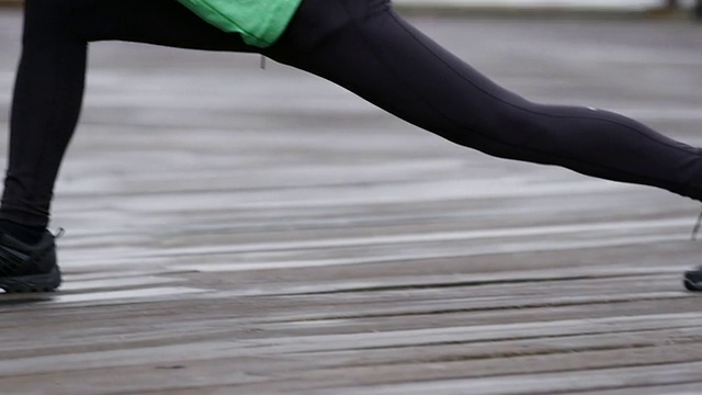 一个男人在雨中跑步前伸伸腿视频素材