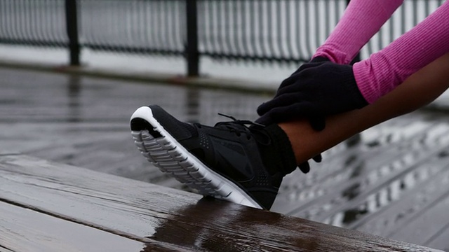 一位女士准备在雨中在布鲁克林大桥公园伸展跑步视频下载