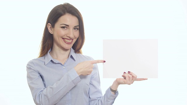 正面微笑的女人指着纸张拷贝空间视频素材