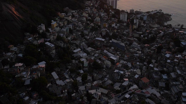 贫民窟日出:壮观的空中贫民窟无人机拍摄黎明破晓的海面上，背景是山脉视频素材