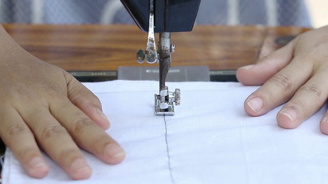 近距离的妇女工作与缝纫机。视频下载