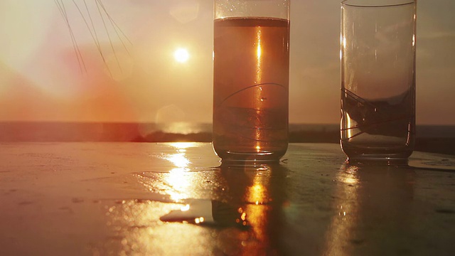 在海边倒杯鸡尾酒:日落，夏日，饮酒视频素材