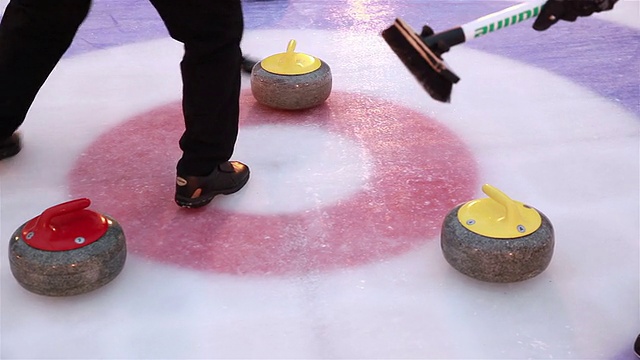 冰壶运动员为了在冰上玩冰壶而扔石头。视频素材