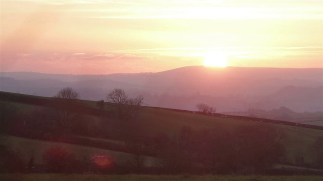 镜头从傍晚的光光晕美丽的日落在农村的农田视频素材