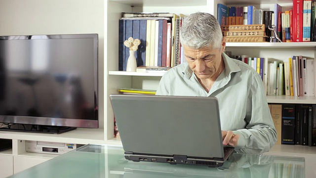 人们在客厅的玻璃桌上使用电脑:网络，科技视频下载
