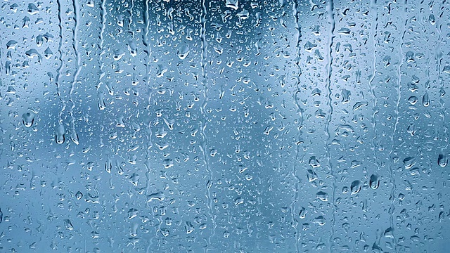 雨滴落在窗户上。蓝色的基调视频素材