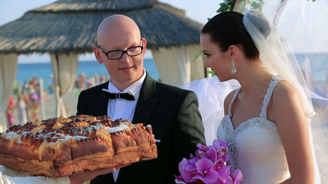 快乐的新婚夫妇掰下一块婚礼面包视频下载