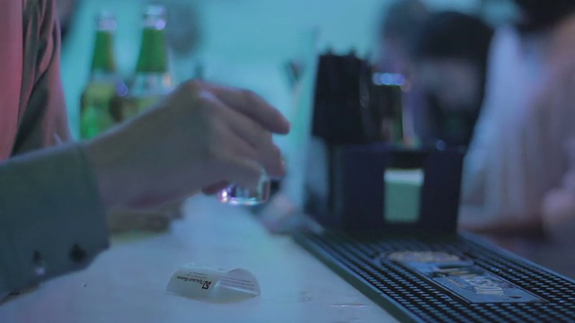 一个男人在吧台喝龙舌兰酒，酒保招待他视频素材