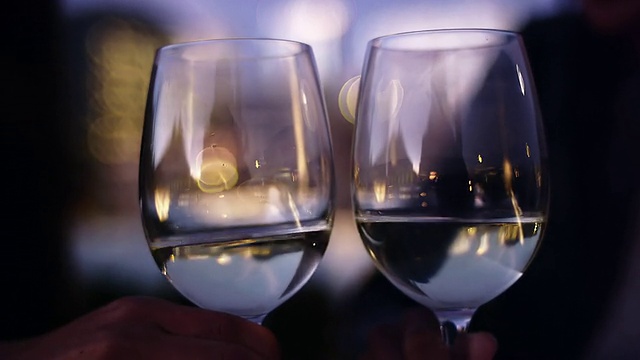 近距离的两个葡萄酒杯正在被敬酒在黄昏视频素材