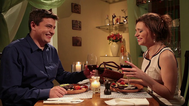 情侣们在烛光下享用浪漫晚餐，男人说祝酒词视频下载
