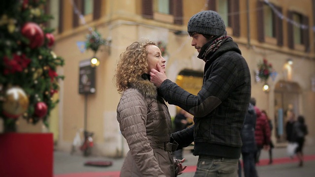 圣诞节期间，一对年轻情侣在大街上相拥视频素材