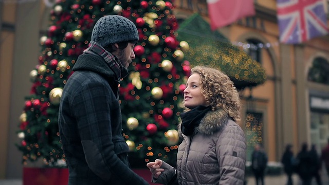 圣诞节期间，一对年轻情侣在大街上相拥视频素材