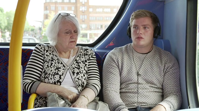 一男子在公共汽车上大声播放音乐干扰乘客视频素材