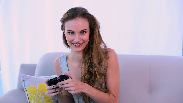 微笑的模特在沙发上玩电子游戏视频下载