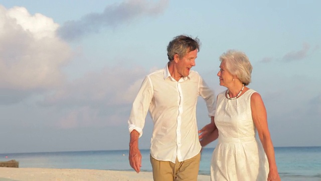 一对老年夫妇在美丽的海滩上散步视频下载
