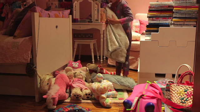 女孩移动玩具在地板上铺床的延时序列视频素材