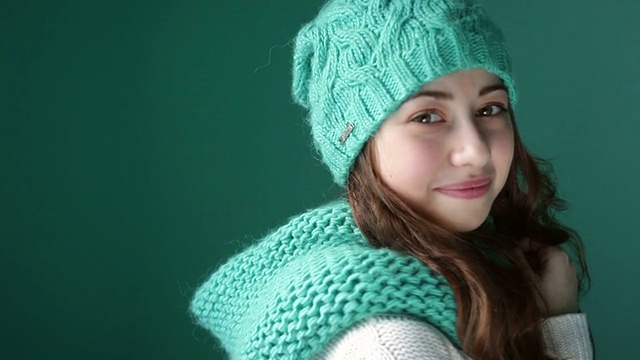 微笑的女孩在绿松石编织帽子摆姿势视频素材