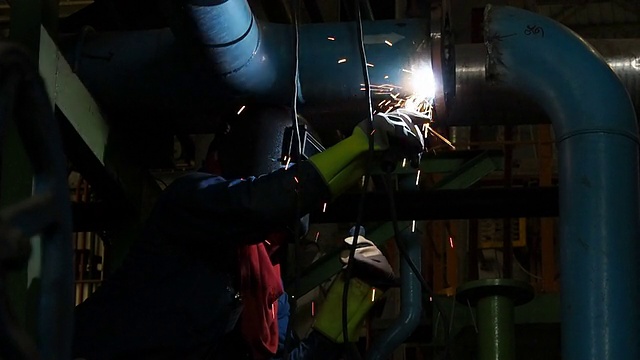 工业工人在工业工厂焊接。视频素材