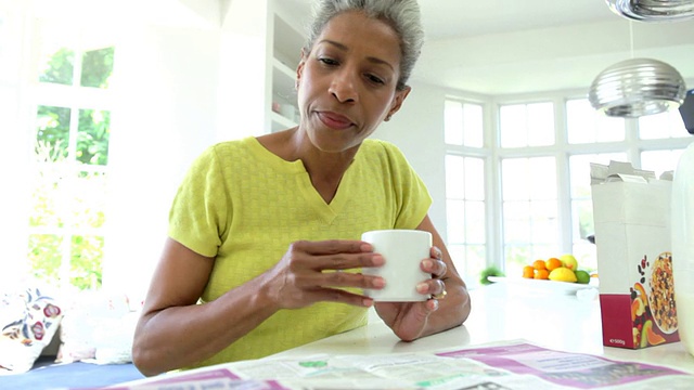 非裔美国妇女吃早餐和看报纸视频素材