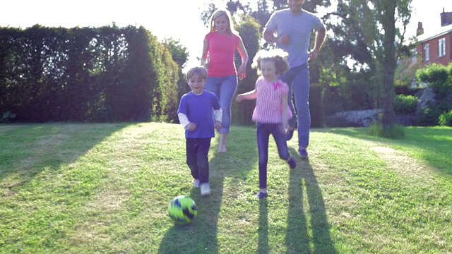 一家人一起在花园里踢足球视频素材