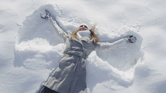 慢镜头:一个女人跳到雪地里，变成了一个天使视频素材