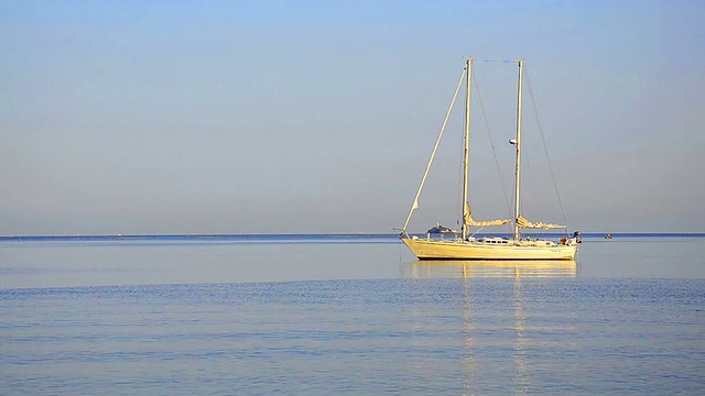一艘帆船在美丽的加勒比海日出环的地平线上视频素材