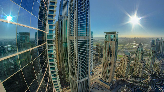 现代摩天大楼在迪拜码头与太阳和反射时间流逝视频素材