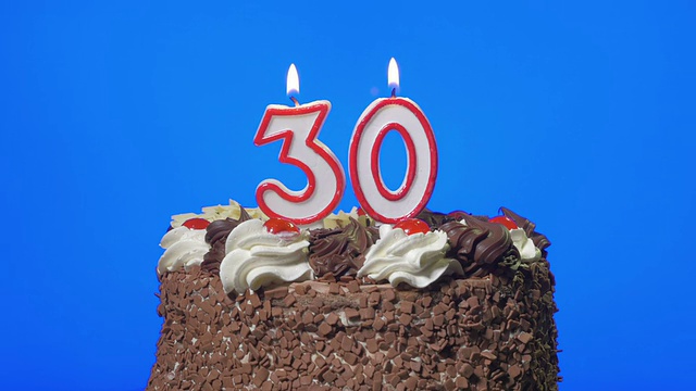 吹三十号生日蜡烛在美味的巧克力蛋糕上，蓝屏视频下载
