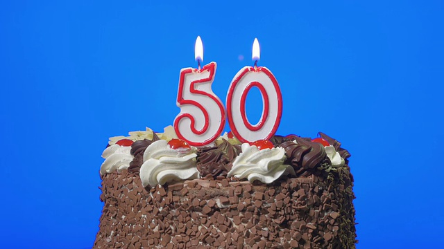 在美味的巧克力蛋糕上吹五十支生日蜡烛，蓝屏视频素材