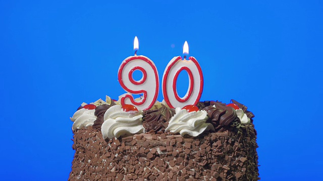 吹灭90号生日蜡烛在美味的巧克力蛋糕上，蓝屏视频下载