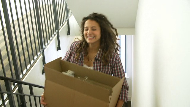 搬着箱子上楼的女人搬进新家视频素材