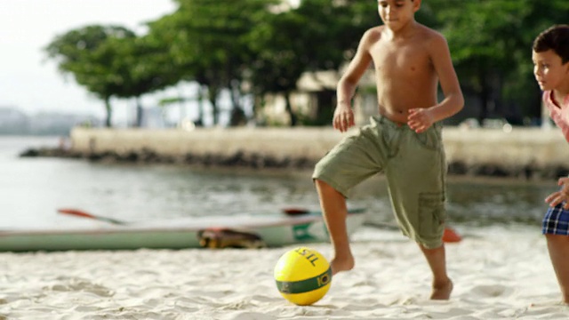 孩子们在巴西的海滩上踢足球视频素材