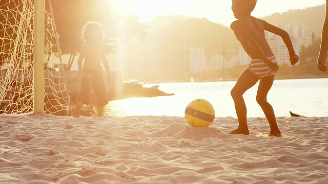 孩子们在巴西的海滩上踢足球视频素材